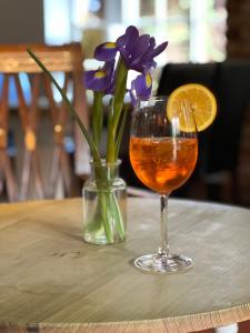 een vaas met paarse bloemen en een drankje op een tafel bij John Barleycorn in Duxford