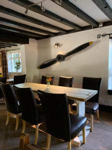 uma sala de jantar com uma grande mesa de madeira e cadeiras em John Barleycorn em Duxford