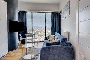 salon z niebieską kanapą i telewizorem w obiekcie Aleda Tower, 14 floor, balkon w Szczecinie