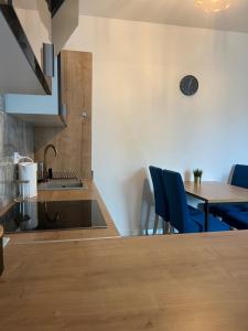 cocina y comedor con mesa y sillas azules en Apartment in Warsaw Cyprysowa, en Varsovia