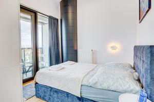 sypialnia z łóżkiem i dużym oknem w obiekcie Aleda Tower, 14 floor, balkon w Szczecinie