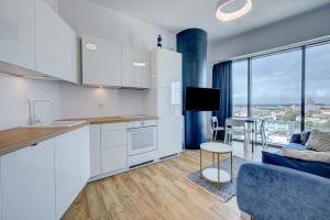 kuchnia z białymi szafkami i salonem w obiekcie Aleda Tower, 14 floor, balkon w Szczecinie