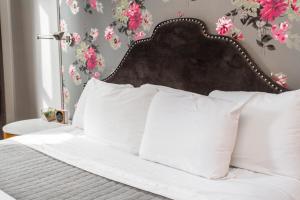 ein Bett mit weißen Kissen in einem Schlafzimmer mit Blumen in der Unterkunft Wicker Park Inn in Chicago