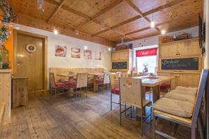 a restaurant with wooden floors and tables and chairs at Engadina B&B in Livigno