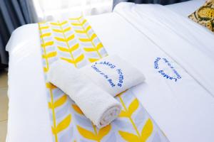 - un lit avec des serviettes dans l'établissement LaMeg Furnished Studio in Coral Bells Apartment, à Kiambu