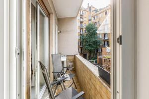 um apartamento varanda com cadeiras e uma janela em Easylife - Spacious apartment in Maciachini em Milão