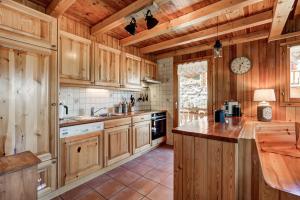 een keuken met houten kasten en een aanrecht bij Chalet Bellevue in La Tzoumaz