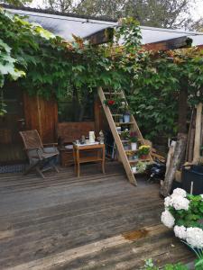 Atelier & Gardenhouse Glamping في ميونخ: سطح خشبي مع طاولة وبيرغولا
