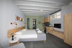 1 dormitorio con 1 cama blanca y cocina en Aperto Apartments en Mykonos ciudad