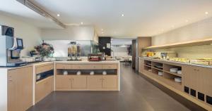 a large kitchen with wooden cabinets in a kitchen at Ilunion Almirante in Barcelona