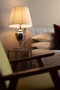 a lamp on a table next to a couch at Caracciolo 13 Rooftop & Suites in Naples