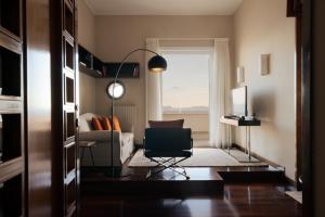 een woonkamer met een stoel en een bank bij Caracciolo 13 Rooftop & Suites in Napels