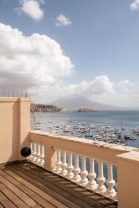 a balcony with a view of the water and boats at Caracciolo 13 Rooftop & Suites in Naples