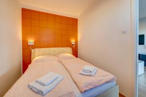 a bedroom with a bed with towels on it at Aleda Kaskada in Szczecin