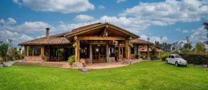 a house with a car parked in front of it at Hacienda Turistica Intihuatana in San Fernando