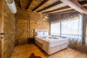 1 dormitorio con 1 cama y pared de madera en Villa Vazgeçilmezim Deniz Manzaralı ,Sessiz,Sakin en Fethiye