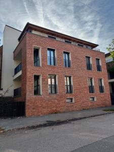 a red brick building with windows on a street at SunSuite Szeged in Szeged +21 photos