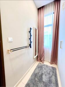 a hallway with a rug and a window at FARIDZ Homestay at Myra Saujana in Kampong Simpang Empat