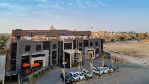 a building with cars parked in a parking lot at Olian Hotel in Riyadh