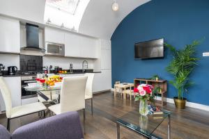 a living room and kitchen with a table and chairs at Stay at Piccadilly in London