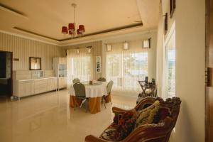 a living room with a table and a kitchen at Hakata Lejja near Natural Hot spring in Batu-Batu