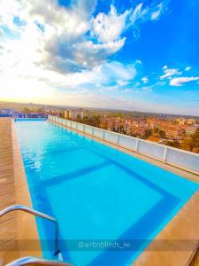 a swimming pool on the roof of a building at LaMeg Furnished Studio in Coral Bells Apartment in Kiambu