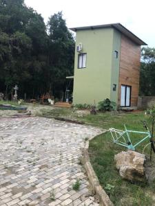 een huis met een stenen loopbrug naast een gebouw bij casa natureza Mariscal in Bombinhas