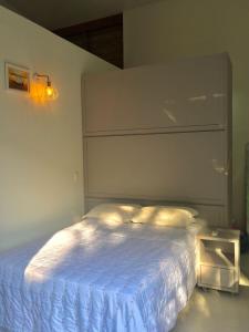 a bedroom with a bed with a white bedspread at casa natureza Mariscal in Bombinhas