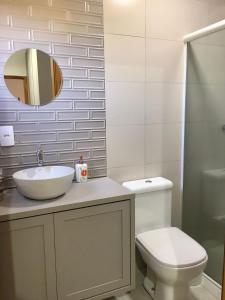 y baño con lavabo, aseo y espejo. en casa natureza Mariscal en Bombinhas