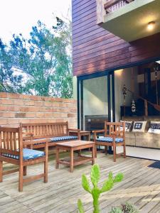 un patio con 3 bancos de madera en una terraza en casa natureza Mariscal, en Bombinhas