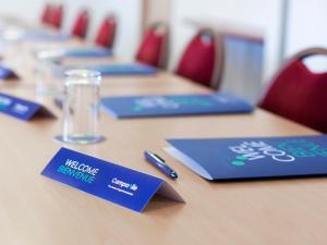 een lange houten tafel met blauwe borden erop bij Campanile Hotel Glasgow SECC Hydro in Glasgow