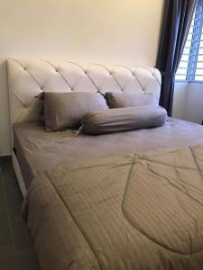 ein großes Bett mit einem weißen Kopfteil und Kissen in der Unterkunft Sofiamuslim Homestay Putrajaya in Putrajaya