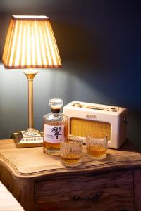 a bottle of whiskey and glasses on a table with a lamp at The Bear in Bath +25 photos