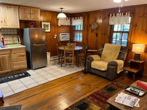 a kitchen with a refrigerator and a chair and a table at Cozy Cabin Pet Friendly ADA Compatible in Maggie Valley