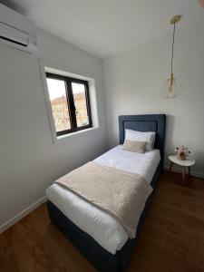 a bed in a room with a window at Barros' House in Chaves