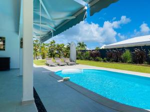 - une piscine avec une terrasse et une maison dans l'établissement Villa Nomilou Beach avec Accès direct Plage, à Saint-François