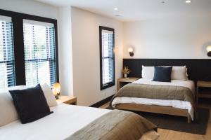 ein Hotelzimmer mit zwei Betten und zwei Fenstern in der Unterkunft The Wildset in Saint Michaels