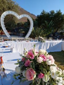 un tavolo con arco a forma di cuore e fiori di Villa Freedom a Kókkinon Khoríon