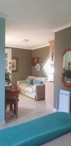 a bedroom with two beds and a table in it at Bienvenue Self Catering in Mossel Bay
