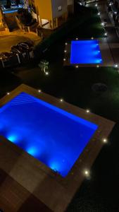 - une piscine avec des lumières bleues dans un bâtiment dans l'établissement Appartement 2 chambres avec 3 piscines et parking gratuit, à Roses