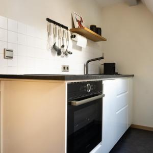 a kitchen with a sink and a black oven at bellasBnB an der Jagst in Möckmühl