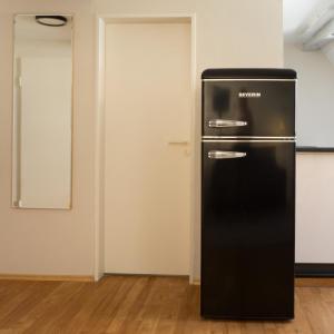 a black refrigerator in a room with a door at bellasBnB an der Jagst in Möckmühl