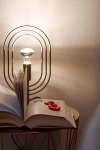 un libro y una lámpara sobre una mesa con luz en Cuore di Relais e Châteaux 5 STELLE in Bellinzona CITY OF CASTLES -By EasyLife Swiss, en Bellinzona