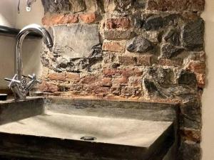 a kitchen sink with a stone wall and a tap at Prione in Genoa