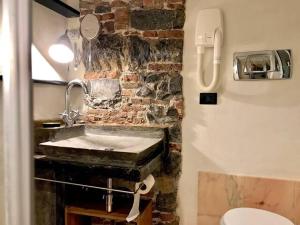 a bathroom with a sink and a brick wall at Prione in Genoa