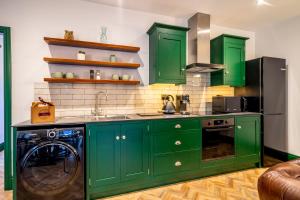 a kitchen with green cabinets and a dishwasher at Tawny Lodge in York
