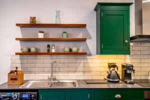 a kitchen with green cabinets and a sink at Tawny Lodge in York