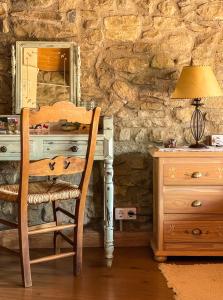 a desk with a chair and a lamp and a dresser at L´estudi in El Meüll