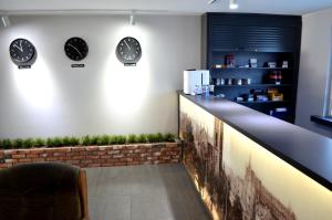 a room with clocks on the wall and a counter at Hostel Malinowski City in Gliwice