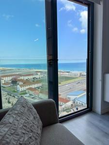 a living room with a large window with a view of an airport at Brand New Top Floor Studio - The Hub Gibraltar - Self Catering in Gibraltar